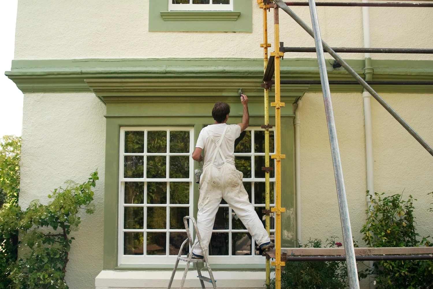 Man painting exterior of house. Home Exterior Blog Post Featured Image